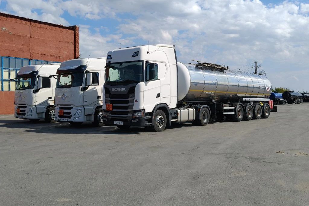 Тягачи Scania и Dongfeng с битумной цистерной на площадке базы